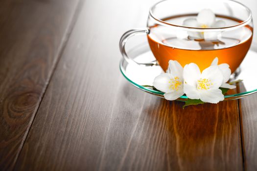 Jasmine tea with jasmine herb flower on wooden background. Copy space 