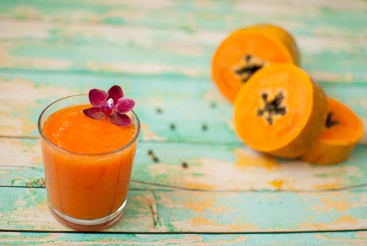 healthy fresh papaya smootie juice on wooden green boards