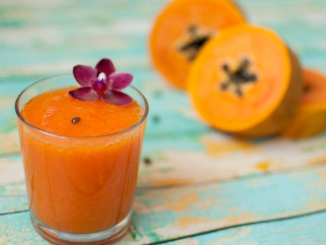 healthy fresh papaya smootie juice on wooden green boards