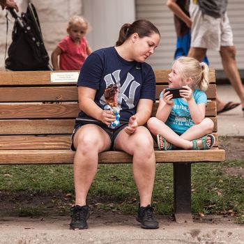DES MOINES, IA /USA - AUGUST 10: Attendees at the Iowa State Fair. Unidentified girls look at smart phone at Iowa State Fair on August 10, 2014 in Des Moines, Iowa, USA.