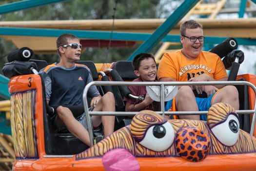 DES MOINES, IA /USA - AUGUST 10: Unidentified boys enjoy a carnival thrill ride at the Iowa State Fair on August 10, 2014 in Des Moines, Iowa, USA.