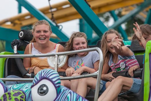 DES MOINES, IA /USA - AUGUST 10: Unidentified girls enjoy a carnival thrill ride at the Iowa State Fair on August 10, 2014 in Des Moines, Iowa, USA.