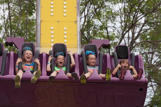 DES MOINES, IA /USA - AUGUST 10: Unidentified girls enjoy a carnival thrill ride at the Iowa State Fair on August 10, 2014 in Des Moines, Iowa, USA.