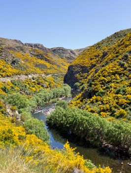 Railway track of Taieri Gorge tourist railway runs alongside river in a ravine on its journey up the valley