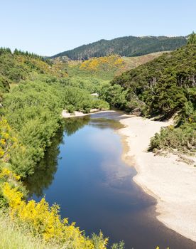 Railway track of Taieri Gorge tourist railway runs alongside river in a ravine on its journey up the valley