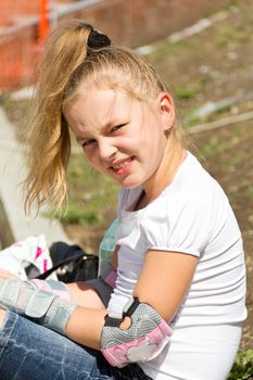 Cute girl put on roller skates in summer