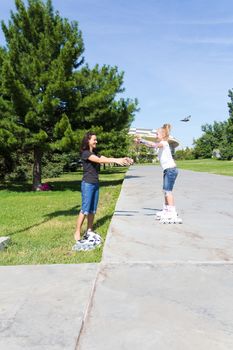 Photo of mother and daughter on roller skates in summer