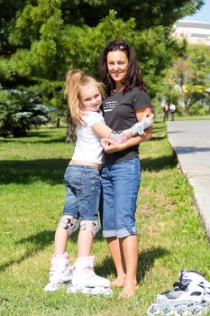 Photo of mother and daughter on roller skates in summer