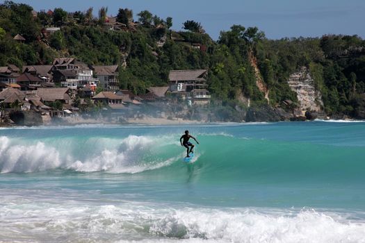 Young men - the surfer in ocean. Bali. Indonesia