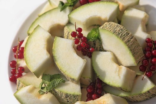 cut melon with red currant
