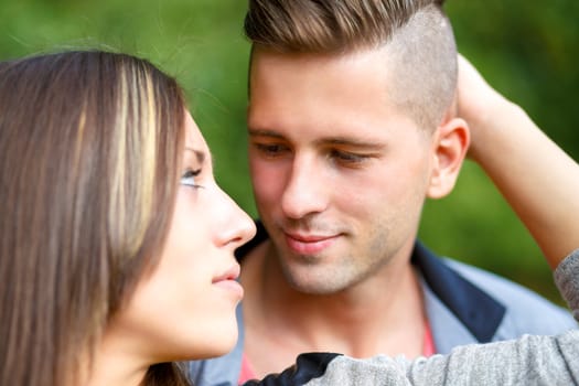 portrait of happy smiling young couple embracing outdoor at sunny day