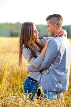 Happy smiling young couple embracing outdoor at sunny day