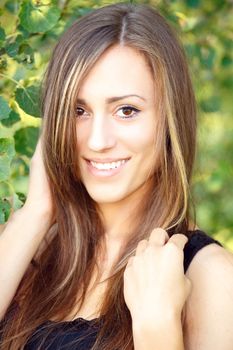 Portrait of smiling and charming lady woman girl outdoor with green background and black dress