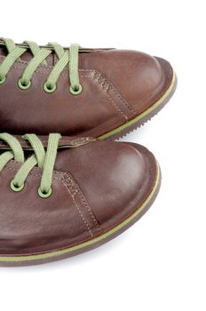Noses of Brown Leather Men Shoes with Green Shoelaces isolated on white background