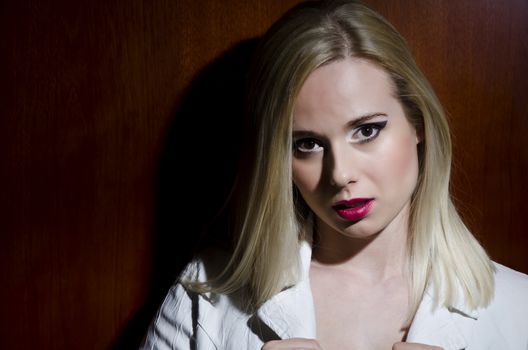 fashion portrait of a blonde woman against a wooden textured background