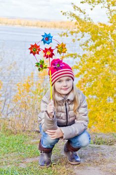 Photo of cute smiling girl in autumn with toy