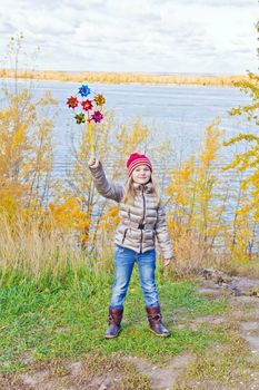 Photo of cute smiling girl in autumn with toy