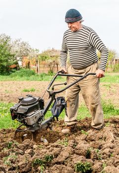 Farmer plowing the field. Cultivating tractor in the field