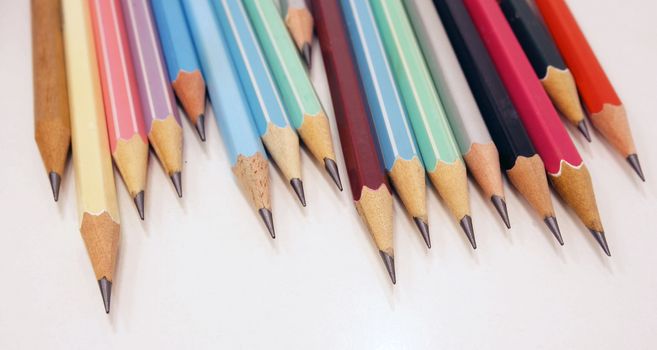 Many pencil have colorful were placed on white table in office.                               