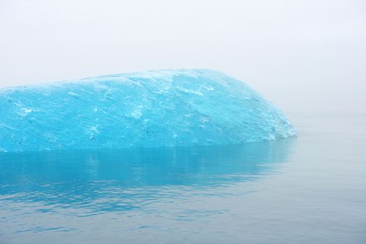 blue iceberg floating in alaska