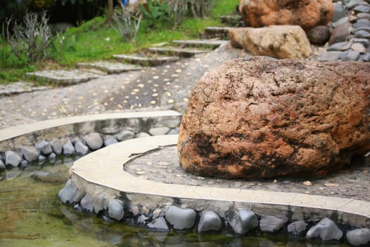 There's a boulder  gardening with the water and marble.