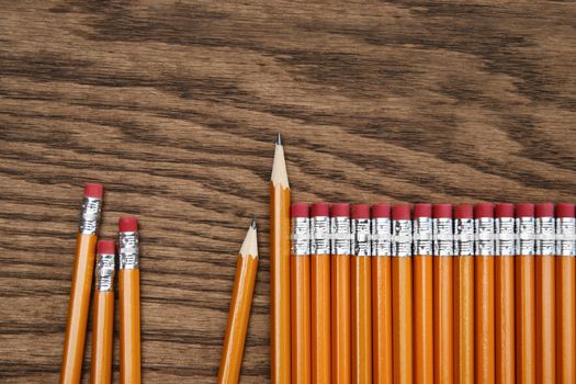 A row of red pencils on wooden surface