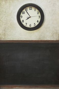 School clock and blackboard with distressed wall