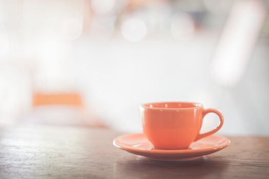 Mini orange coffee cup on wooden table, stock photo