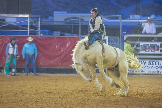 LOGANDALE , NEVADA - APRIL 10 : Cowboy Participating in a Bucking Horse Competition at the Clark County Fair and Rodeo a Professional Rodeo held in Logandale Nevada , USA on April 10 2014 