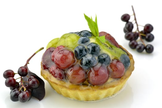 Fresh yummy tart made decorated with grape and berries on white background