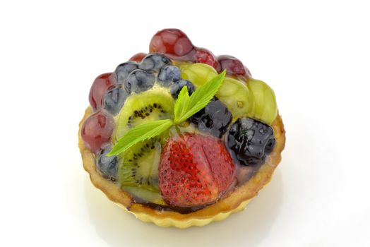 Fresh yummy tart made decorated with grape and berries on white background
