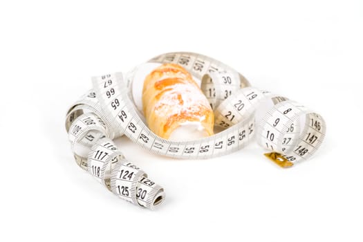 concept of slimming, cakes with measuring tape on white background