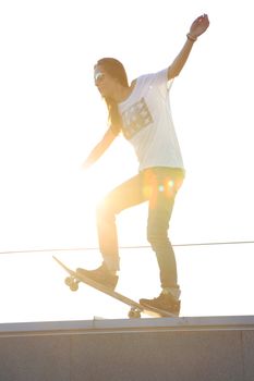 Young girl on the roof relaxes in the rays of the setting sun