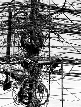 Electric wires on a post in Kathmandu, Nepal in black and white