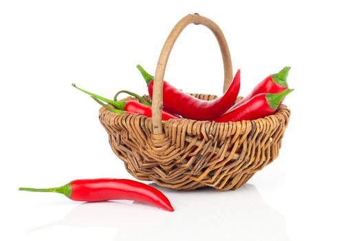Red chili pepper in a wicker basket, isolated on white background