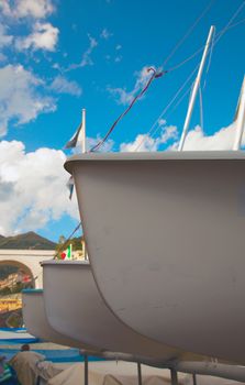 Bows of three boats aligned, under blue sky