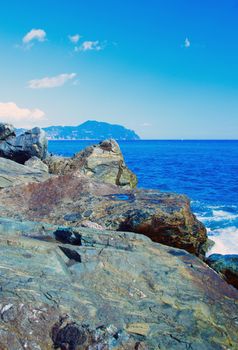 Rocks on the coast with deep blue sea on the back, vertical image