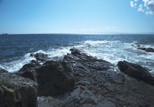 Rocks on the coast with deep blue sea on the back, horizontal image