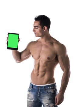 Sexy muscular shirtless young man holding a blank tablet PC while looking at it, portrait on white