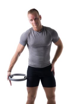 Young muscular man exercising with Pilates ring against thigh, isolated on white