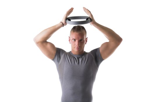 Young muscular man exercising with Pilates ring above his head, isolated on white
