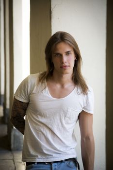 Handsome Long Hair Man in White Shirt Standing Besides Hallway