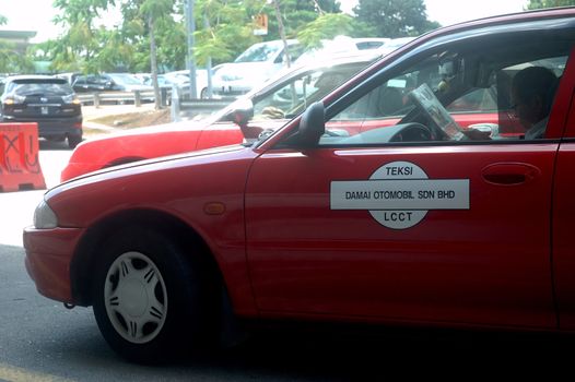 KLCCT, Malaysia - June 7, 2013: Red colored taxi that operated in Kuala Lumpur Low Cost Carrier Terminal (KLCCT), Malaysia.