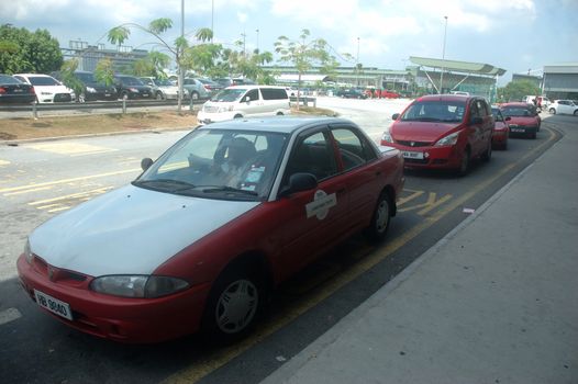 KLCCT, Malaysia - June 7, 2013: Red colored taxi that operated in Kuala Lumpur Low Cost Carrier Terminal (KLCCT), Malaysia.