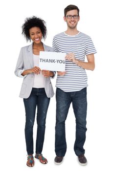 Full length portrait of a smiling couple holding a thank you note over white background