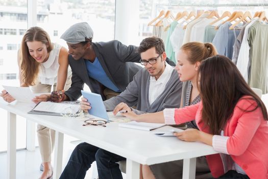 Group of fashion designers discussing designs in a studio