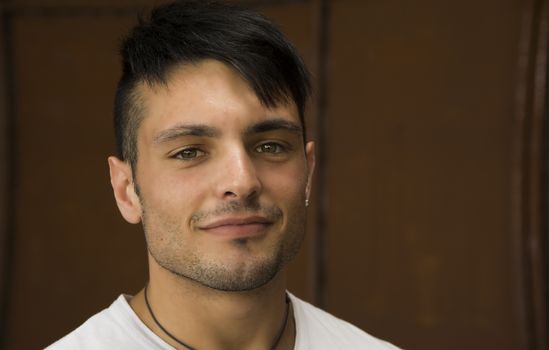 Headshot of smiling attractive young man in white shirt