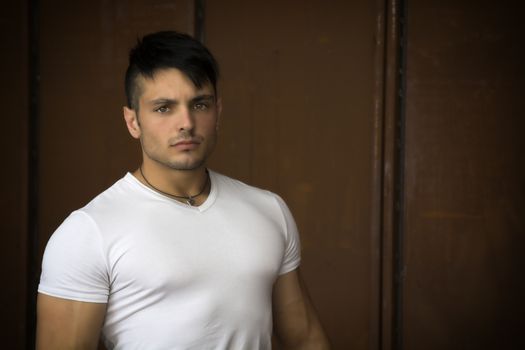 Attractive young muscular man portrait in white shirt posing