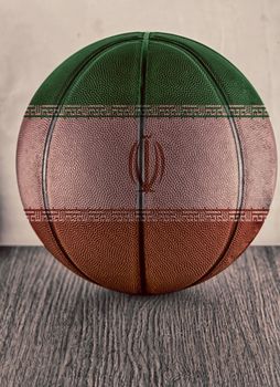 Basketball with flag of Iran, over wooden surface