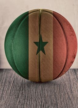 Basketball with flag of Senegal, over wooden surface